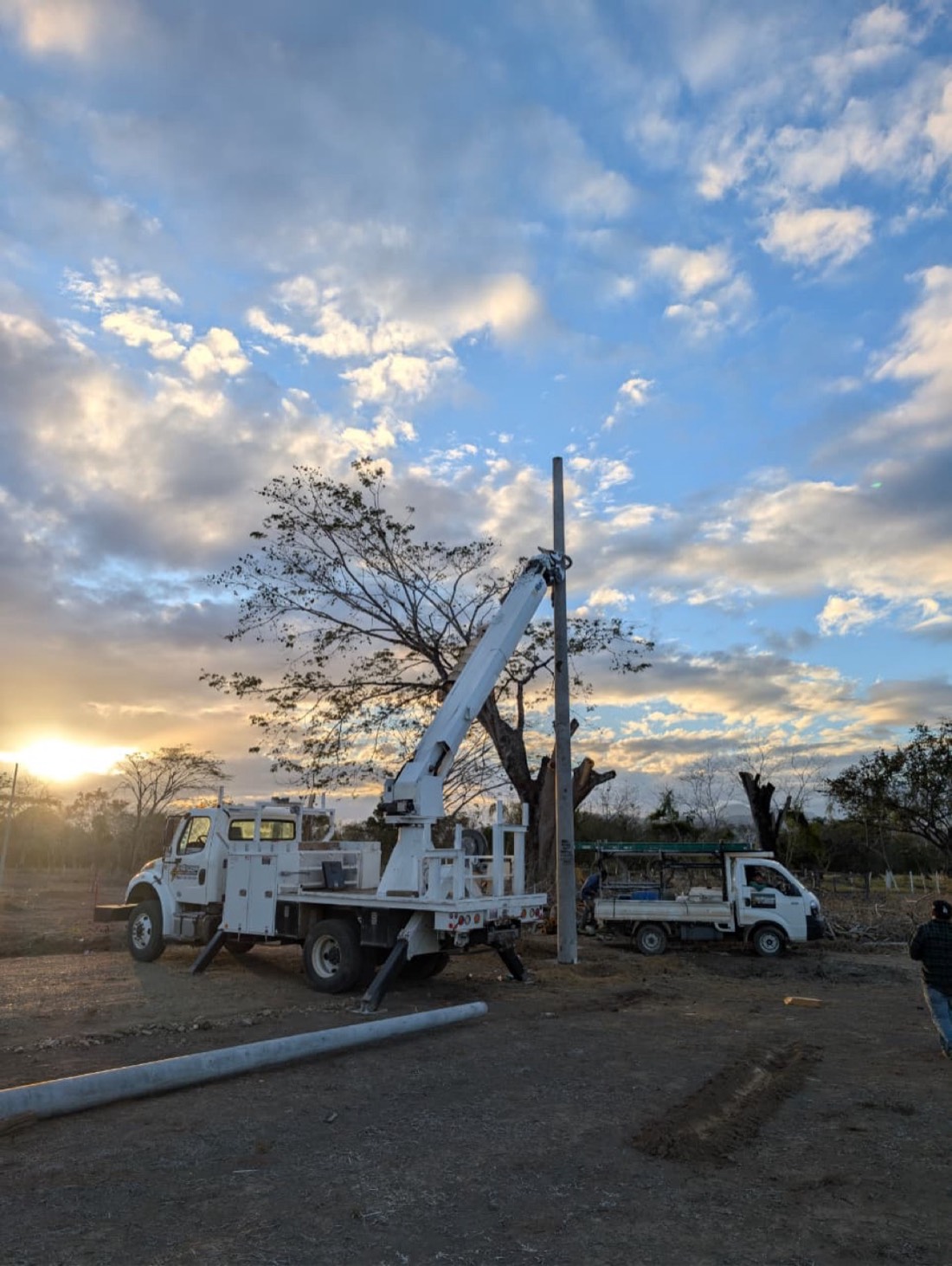Camión grúa instalando postes en urbanización Brisas de Guayape