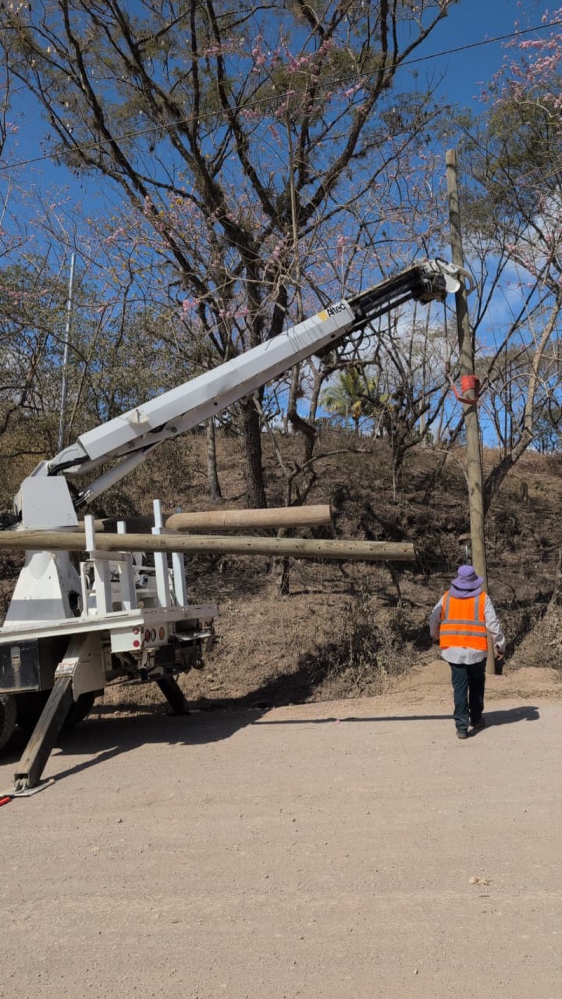 Grúa colocando postes para reubicación de circuito eléctrico